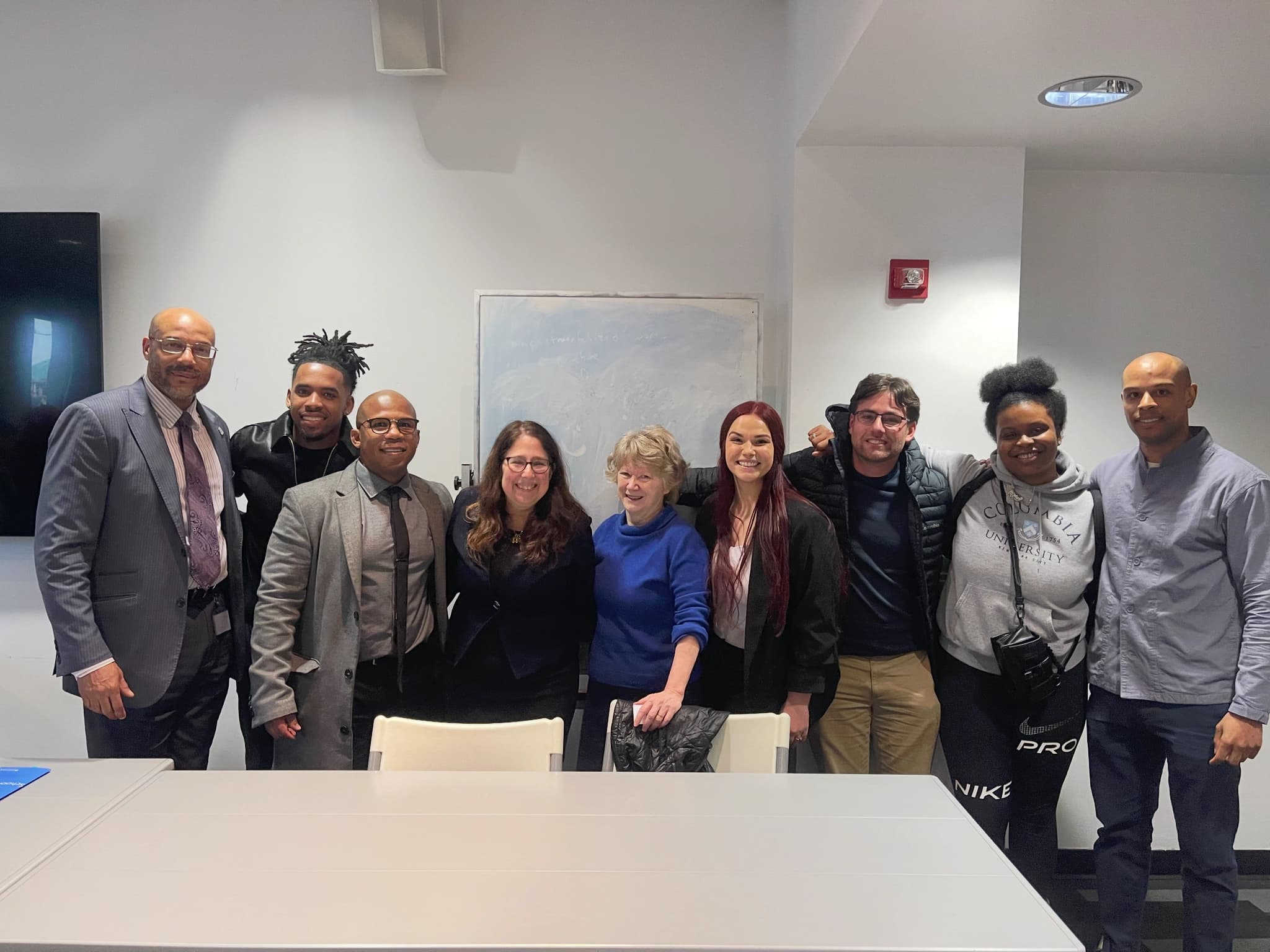 System Impacted Scholars members and guests standing together in a classroom